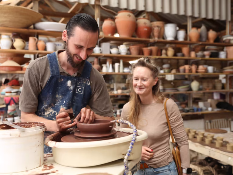 Sarah from Cupper's Journey watching a potter carefully create ceramics at Corinne de Hass in South Africa